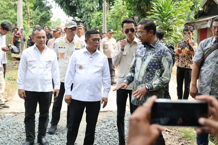 Andra Soni dan Kadis PUPR Arlan Marzan menginspeksi hasil pembangunan jalan beton desa TA 2025