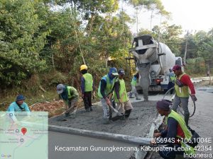Pekerja proyek PUPR meratakan semen cor rigid jalan dari truk molen ready mix di Lebak Banten